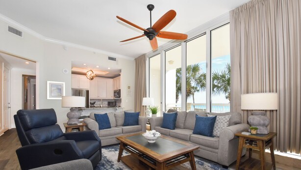 A spacious living room with a ceiling fan, a sofa set, a coffee table, and a view of the outdoors. - Lobby-level, coastal contemporary beachfront condo! 🏖️ (Destin)