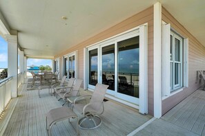 Relax in a serene outdoor space with large windows offering views of the surroundings, wicker chairs for seating, and a clean, inviting atmosphere.