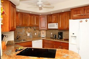 Fully equipped kitchen with appliances, including a microwave, coffee maker, refrigerator, dishwasher, and stove.