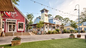A building with a red exterior and a sign for 'Ice Cream & Desserts'. - Condo at Baytowne! Large Balcony, Tropical Pool, Walk to Wharf, Tram to Beach (Miramar Beach)