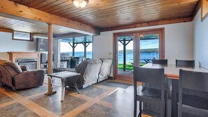 Un salon chaleureux avec une cheminée, des sièges confortables et une vue sur un lac.