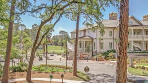 A large building with a formal entrance, a landscaped garden, and a golf course in the background. - 913 Cutter Ct- Short Stays All Summer - Steps to Harbour Town and Marina (Hilton Head Island)
