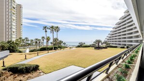 A hotel with a view of the beach, palm trees, and ocean.