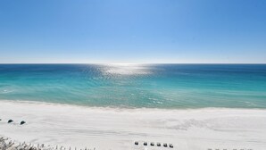 A beach with clear blue water and a sandy shore.