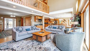 A spacious living area with two grey sofas, a wooden coffee table, and a patterned rug. - Dog Friendly Lakefront Home w/ Dock & Hot Tub (MCHENRY)