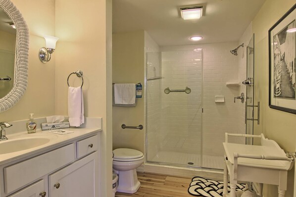 A bathroom with a sink, toilet, and glass-enclosed shower.
