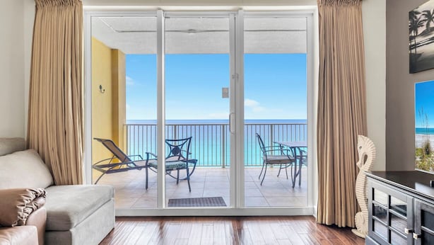 A room with a sliding glass door leading to a balcony with outdoor furniture.