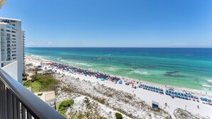 A beach with a view of the ocean and a building in the background. - Beachfront Condo w/ GOLF CART, Furnished Balcony, Gulf View, Pool, Beach Tram (Miramar Beach)