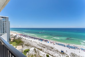 A beach with a view of the ocean and a building in the background.
