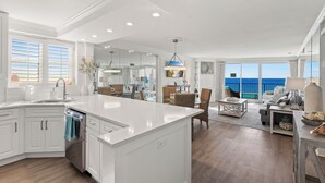 A spacious kitchen with a large island, white cabinetry, and a view of the ocean. - Beachfront Condo w/ GOLF CART, Furnished Balcony, Gulf View, Pool, Beach Tram (Miramar Beach)