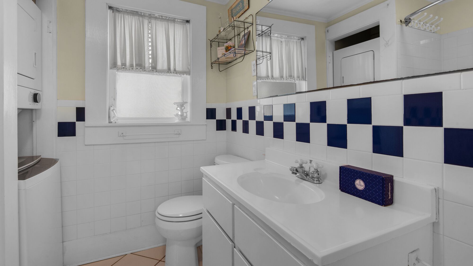 A bathroom with a toilet, sink, and a shower area.