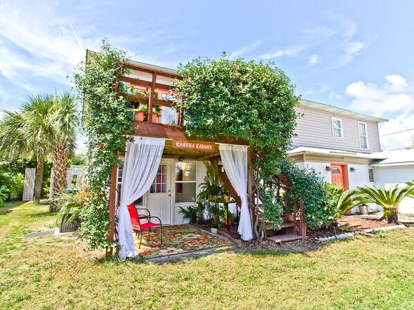 A two-story house with a covered porch and a sign that reads "KAHUNA KABANA". - Kahuna Kabana | Popular Beach Rental, Near Beach! (Tybee Island)