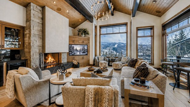 A spacious living area with a fireplace, large windows, and a view of the outdoors.