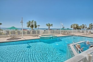 Relax by the resort's inviting pool, surrounded by palm trees and lounge chairs.