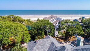 Un quartier résidentiel avec des maisons, des arbres et une plage en arrière-plan.