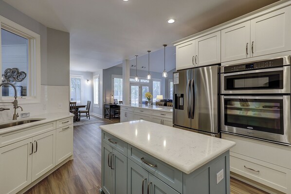 A modern kitchen with white cabinetry, stainless steel appliances, and a marble countertop. - 7 Quail-Dog-Friendly, 2nd Row Ocean w/ Pool & Hot Tub, 35 steps to the beach! (Hilton Head Island)