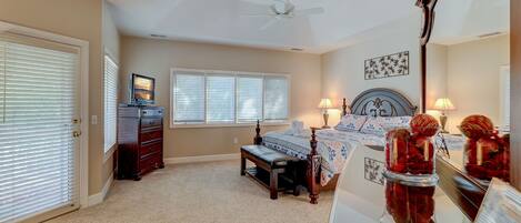 A bedroom with a bed, a dresser, a bench, a ceiling fan, and a window with blinds.