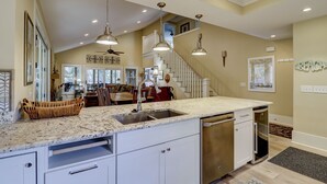 A spacious kitchen with granite countertops, a dishwasher, and a stainless steel sink. - 231 Beachside Homes-3 min walk to the beach (352 yards) or South Beach Marina (Hilton Head Island)