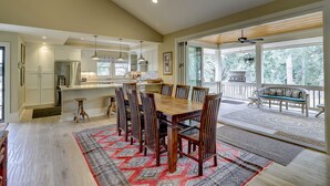 A spacious kitchen with a large island, a dining area with wooden chairs, and a patio with a grill and seating. - 231 Beachside Homes-3 min walk to the beach (352 yards) or South Beach Marina (Hilton Head Island)