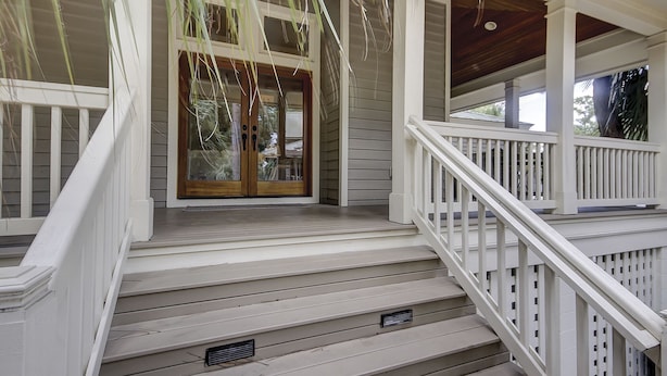 A covered porch with a wooden staircase and white railings. - 233 Beachside Home- Large 4 Bedroom Homes with Heated Community Pool (Hilton Head Island)