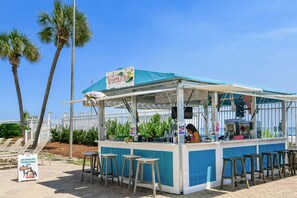 A beachside food kiosk with a sign reading 'TipSeaTurtle,' featuring a counter, stools, and a menu board. - Tropical Beachfront Condo w/ Private Balcony & Stunning Gulf Views in Destin! 🐬 (Destin)