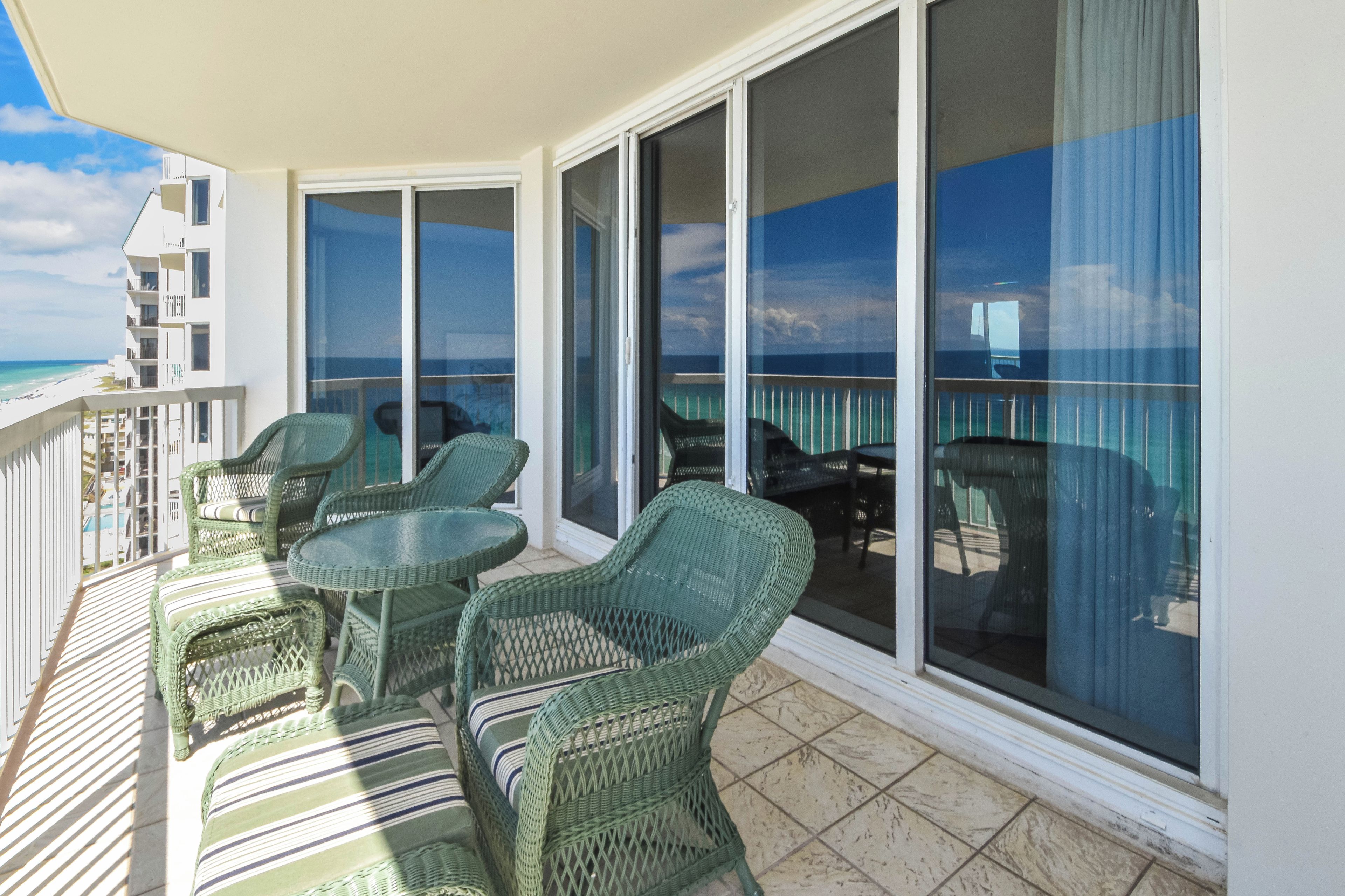 Ein Balkon mit Korbmöbeln und Blick auf den Ozean.