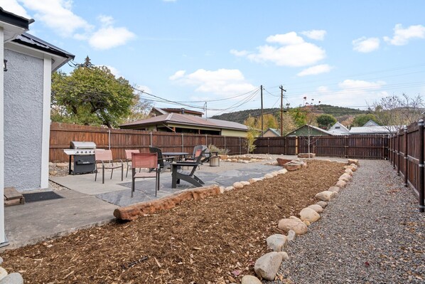 A backyard with a barbecue area, patio furniture, and a wooden fence. - Downtown Location, 5 Min Walk to Train, Great Yard (Durango)