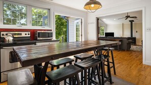 Eine moderne Küche mit einer großen Kochinsel, Barhocker und einem Essbereich mit Sofa und Fernseher.
