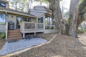 A two-story house with a deck, large windows, and a tree in the background. - 34 Muirfield. Quick walk to all Harbour Town has to offer (Hilton Head Island)