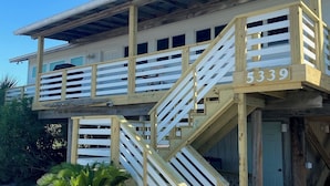 A two-story building with a wooden staircase and balcony. - One Lot From Beach, Gulf View, Private Beach Boardwalk, Dune Allen Beach (Santa Rosa Beach)
