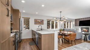 A modern kitchen with wooden cabinets, stainless steel appliances, and a central island. - Ski-In and Out in Beaver Creek Village Condo w/ Balcony, Hot Tub, Free Shuttle  (Beaver Creek)