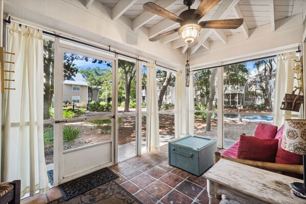 A sunroom with a sliding glass door, a ceiling fan, and a view of the backyard.