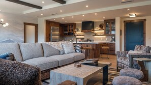 A modern living room with a sofa, coffee table, and patterned cushions.