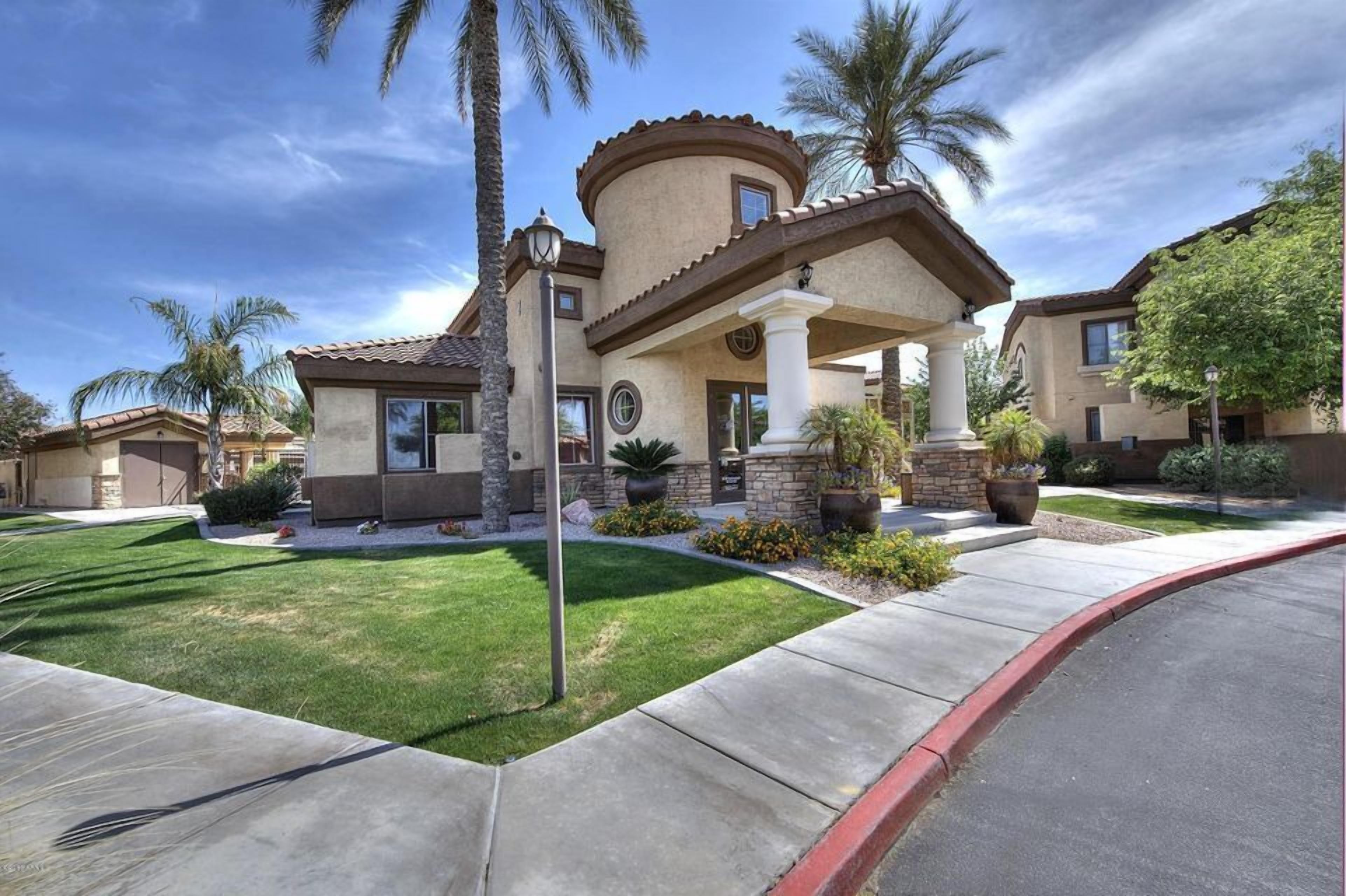 A residential house with a curved roof, a stone facade, and a well-maintained lawn.