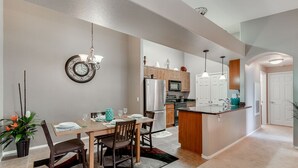 A modern kitchen with wooden cabinets, a central island, and stainless steel appliances. - 2BR condo w community pool, hiking trails (Mesa)