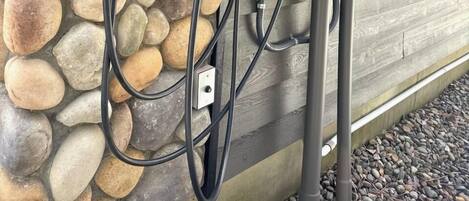 A stone wall with a power outlet and a charging station.