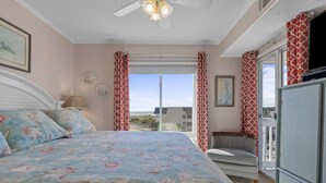 Une chambre avec un lit, une chaise, une télévision et une vue sur l’extérieur.