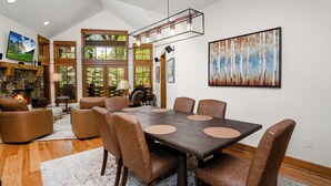 A dining area with a rectangular table, six chairs, and a fireplace. - Roomy, Luxurious Ski-In/Ski-Out w/ Views, Hot Tub! Bachelor Gulch, Beaver Creek (Edwards)