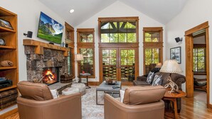 A cozy living room with a stone fireplace, leather sofas, and large windows. - Roomy, Luxurious Ski-In/Ski-Out w/ Views, Hot Tub! Bachelor Gulch, Beaver Creek (Edwards)
