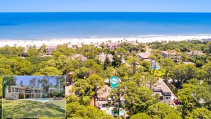 A coastal residential area with a beach view, houses surrounded by trees, and a swimming pool.