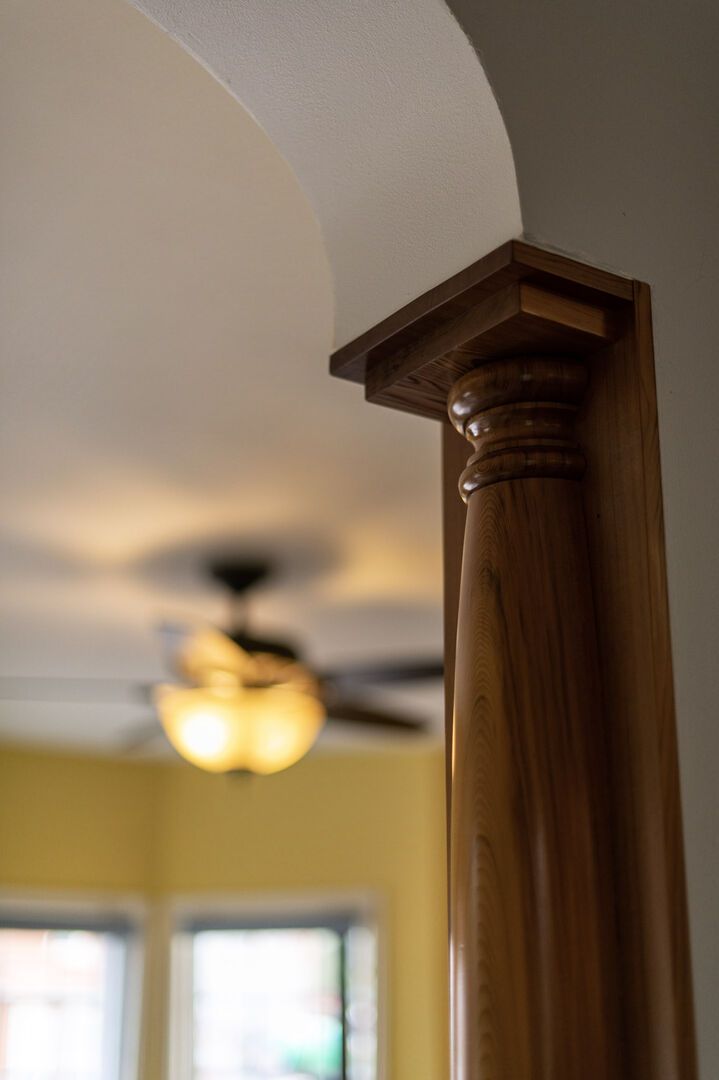A wooden column with a rounded top, part of a ceiling structure.