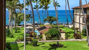 A resort with a pool, lounge chairs, and palm trees.