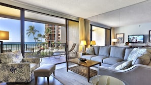 Relax on the balcony overlooking the beach and palm trees, with a comfortable seating area and stunning views.