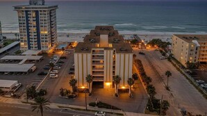 Un albergo con piscina sul tetto, parcheggio e vista sulla spiaggia.