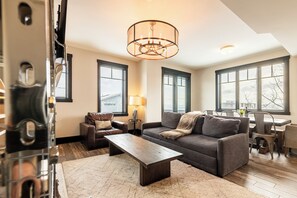 A living room with a sofa, coffee table, and a chandelier.