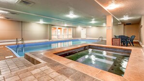 An indoor swimming pool with a separate hot tub area, tiled flooring, and a seating area with chairs and a table. - Perfect Downtown Retreat with ALL NEW APPLIANCES AS OF FALL 2025! (Breckenridge)
