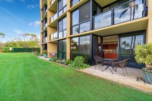 Ein modernes Gebäude mit mehreren Etagen, großen Fenstern und einem gepflegten Rasen mit Außenplätzen.