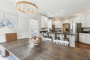 Enjoy meals in this kitchen with a dining table, refrigerator, and microwave.