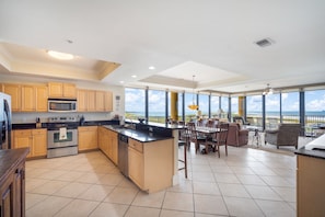 A spacious kitchen with a large island, stainless steel appliances, and wooden cabinets.