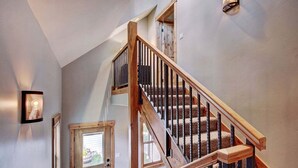 Una escalera con barandillas de madera y un rellano alfombrado.